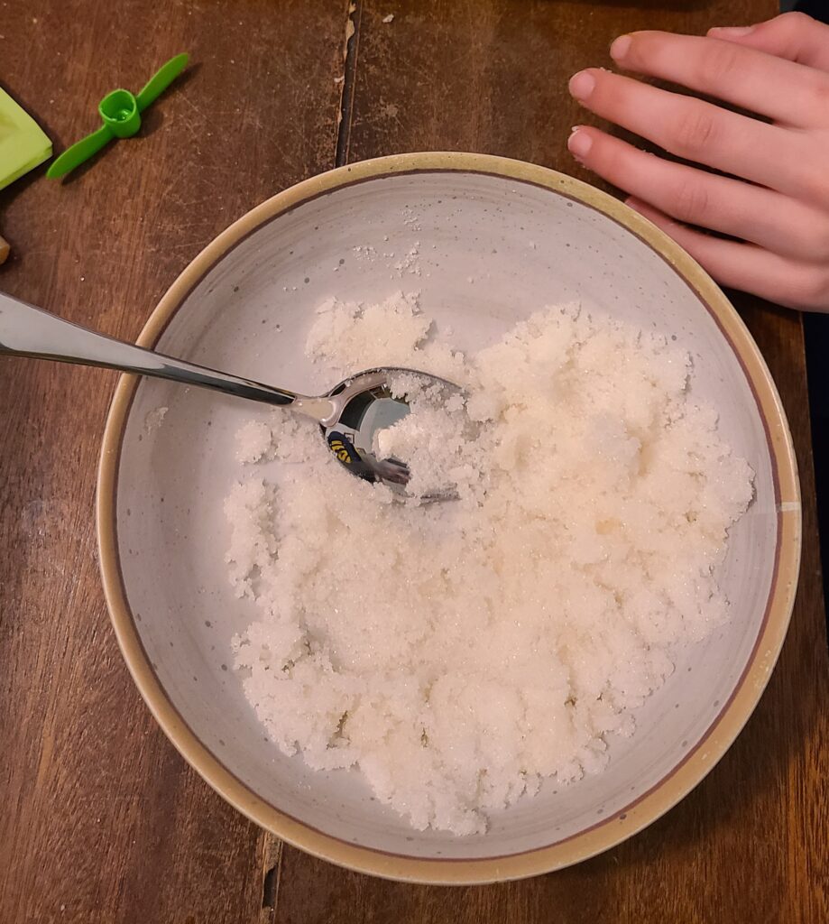 Sugar, applesauce, and water mixed with a spoon to make sugar cubes for horses