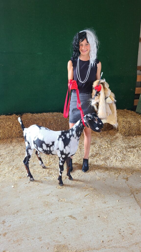 Girl and goat dressed up as Cruella and Dalmation 