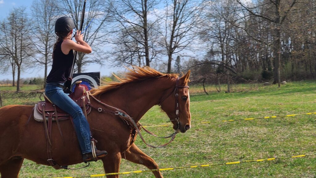 Girl shooting a bow on a horse because geldings are better
