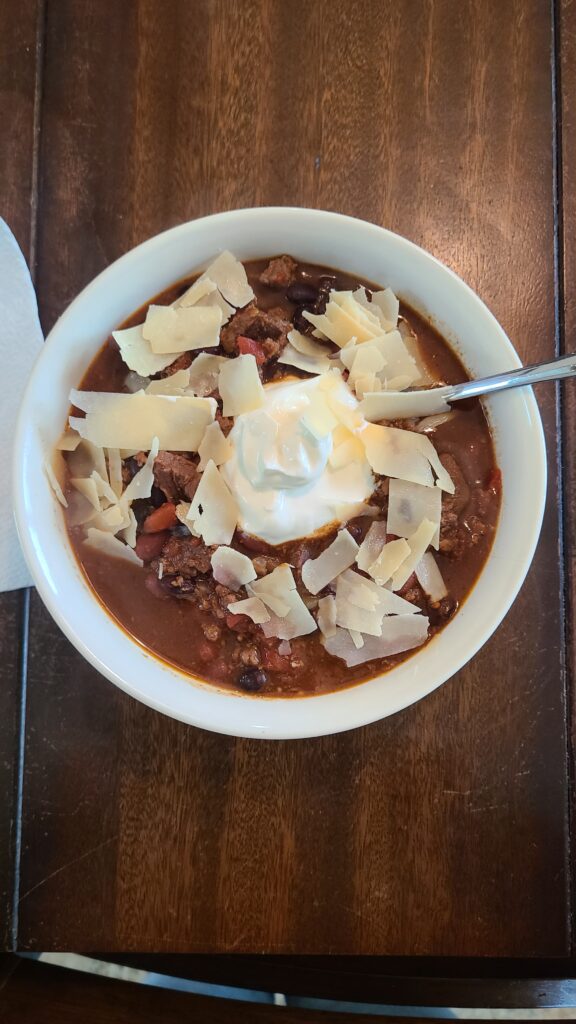 Bowl of chili with cheese and sour cream on top