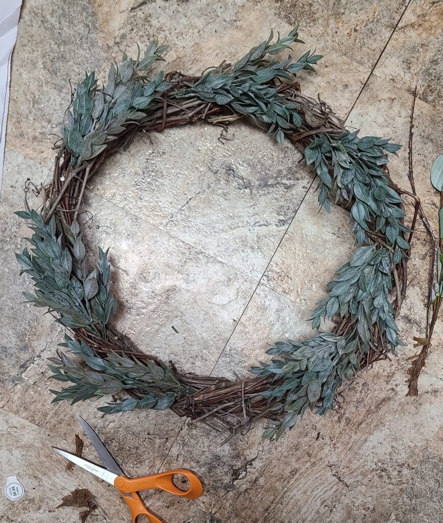 Greenery added to decorate a grapevine wreath
