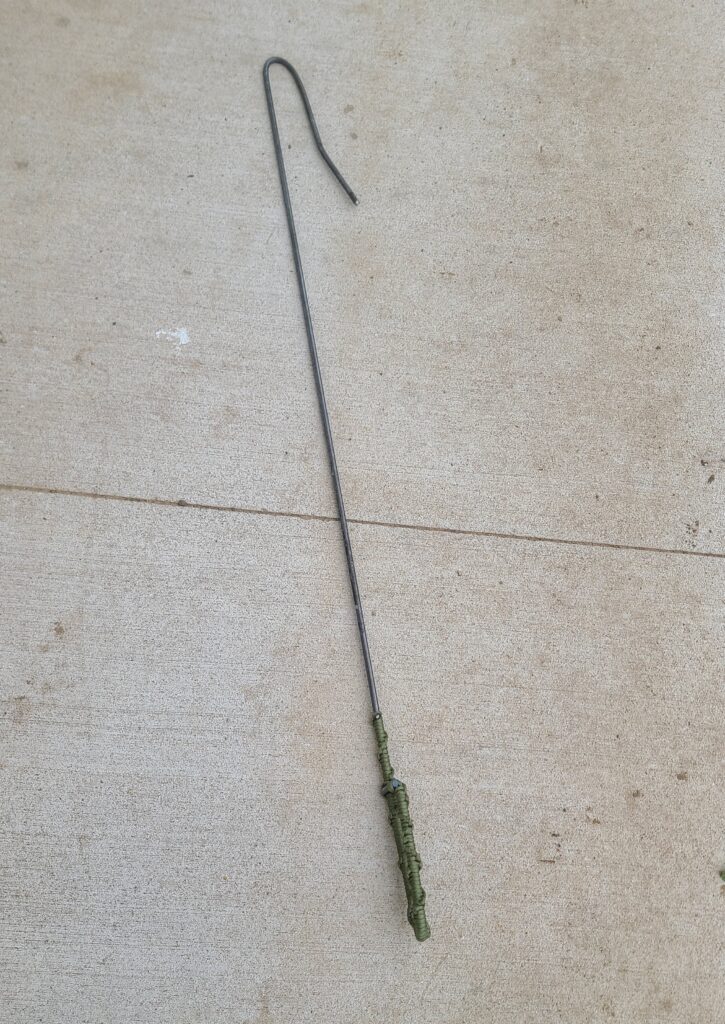 Homemade leg hook for catching goats, wrapped in paracord