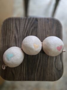 Three handmade dryer balls inside a pantihose ready to go into the washing machine.