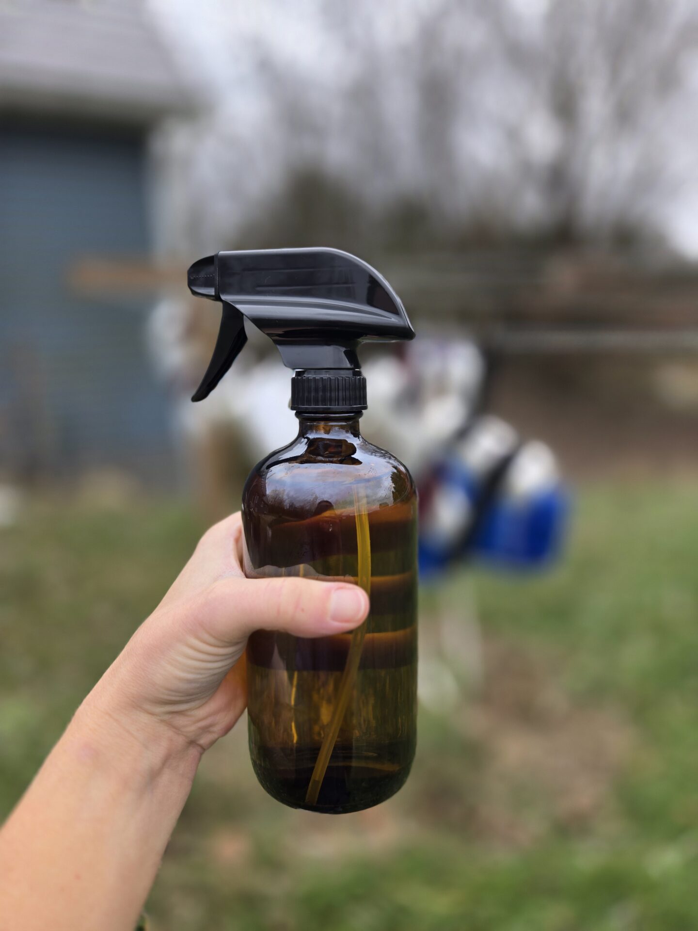 A bottle of homemade antifungal spray in front of a clothesline.