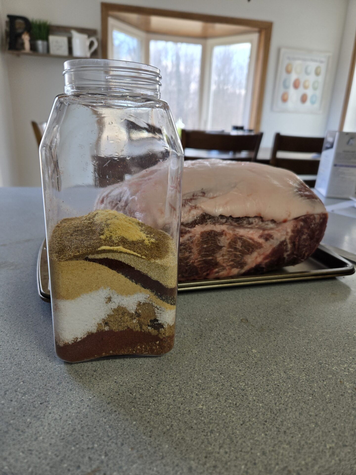 Pork shoulder with homemade rub sitting in front of it.