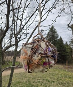 Grapevine nesting ball for birds filled with natural fiber.