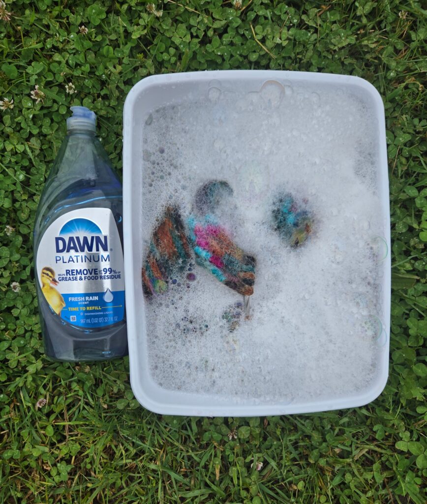 Dawn dish soap next to a dishpan used to wash a mohair breast collar.