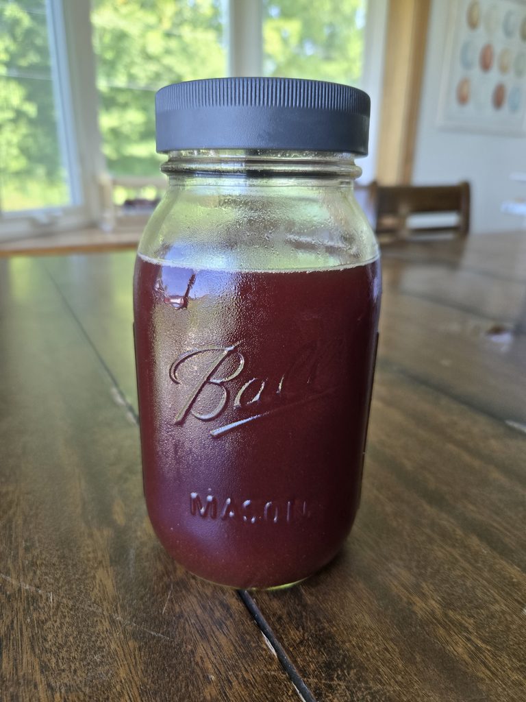 Spiced elderberry syrup in a Mason jar.
