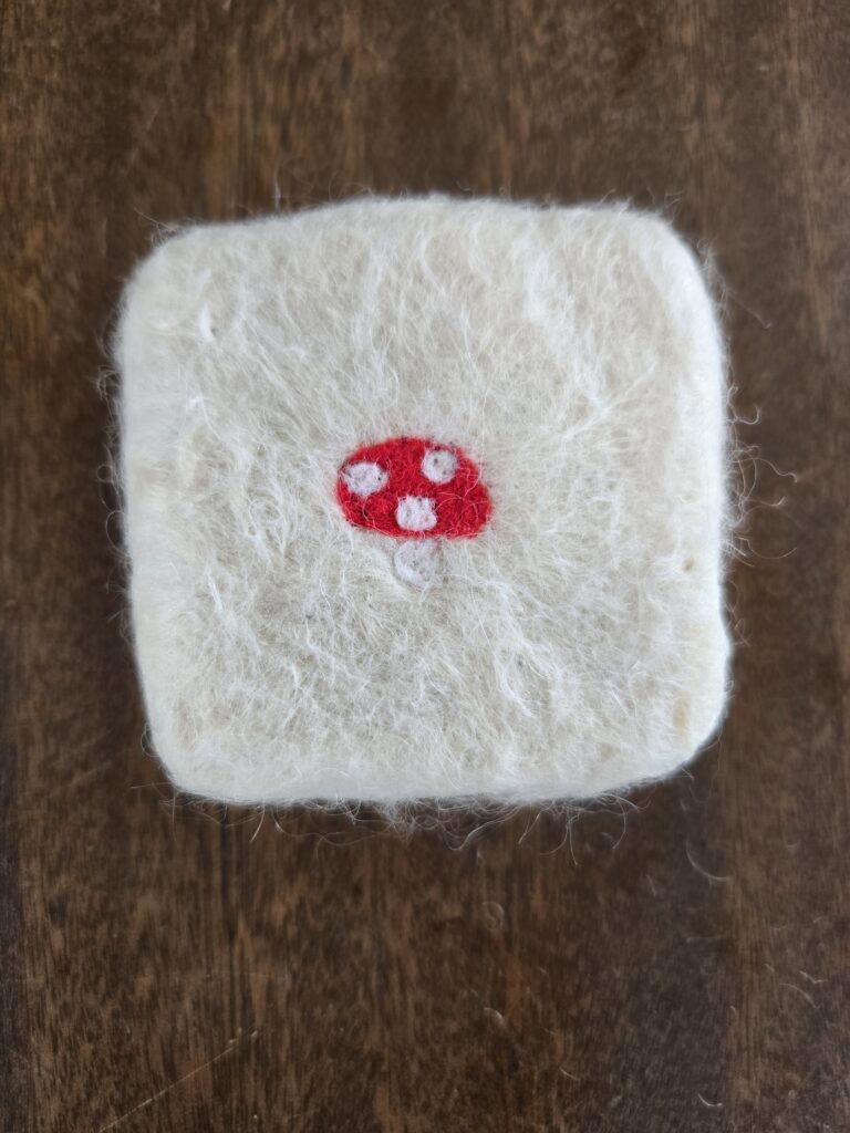 Felted soap with a mushroom decoration.