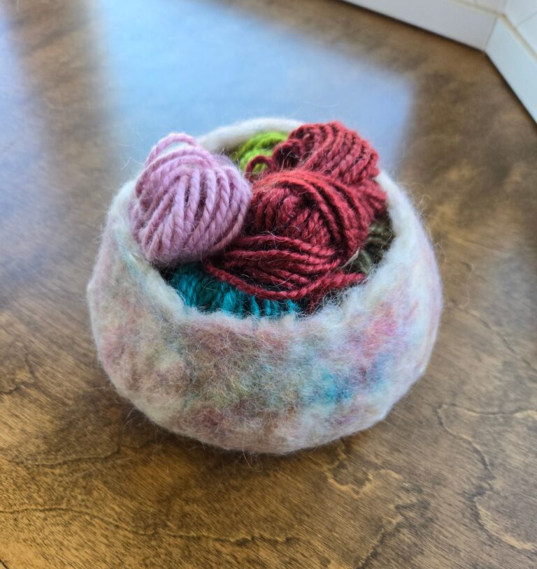A wet-felted bowl holding yarn.
