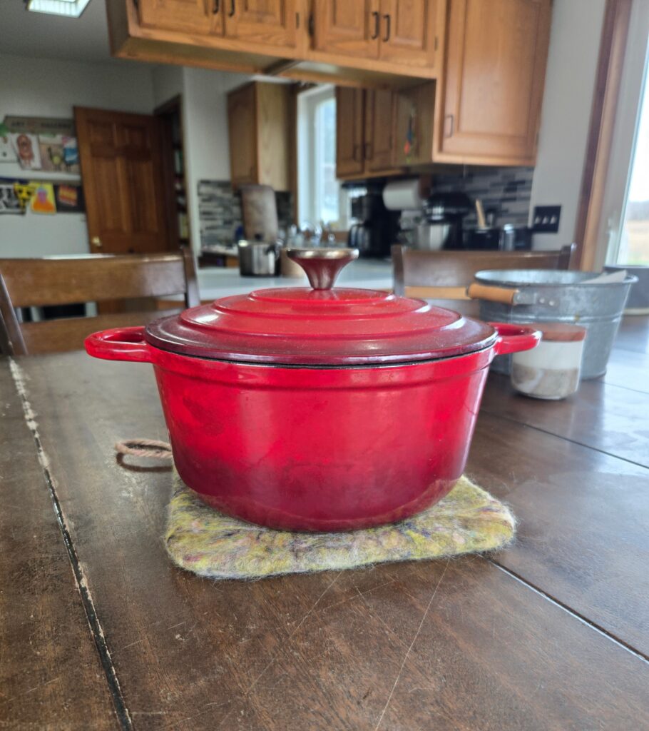 Felted wool hot pad under a Dutch oven.