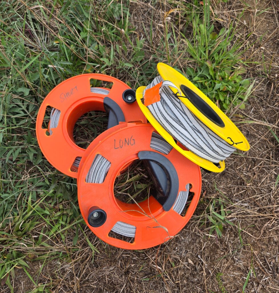 Reels for holding poly-tape electric fencing.