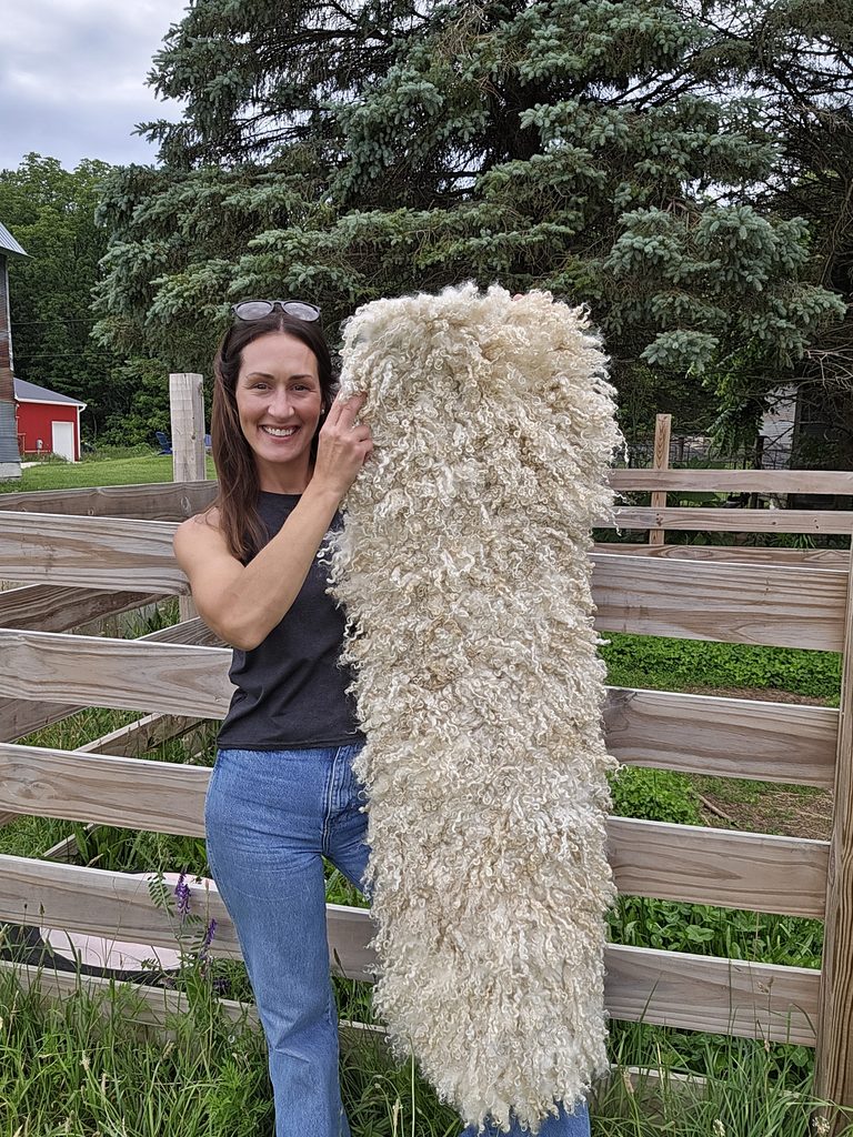 A woman holding a handmade mohair lock rug.
