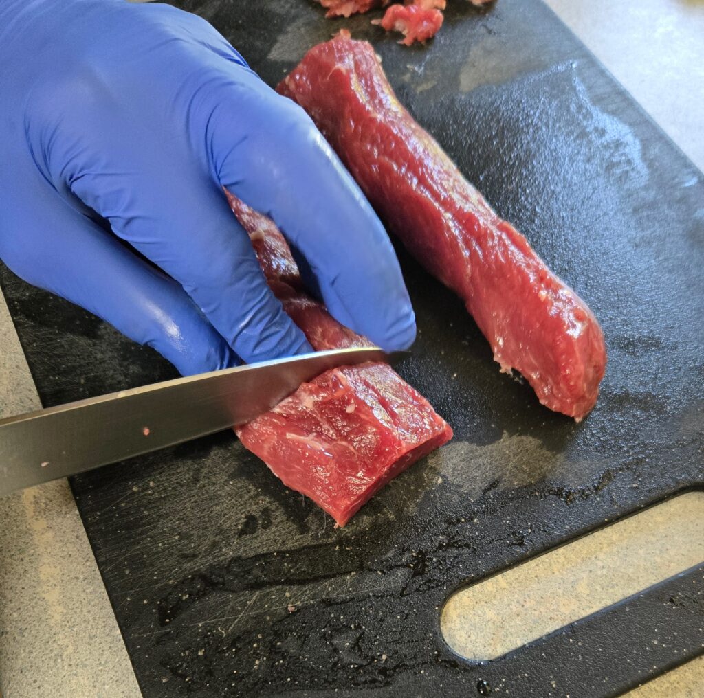 Cutting goat loin into medallions 