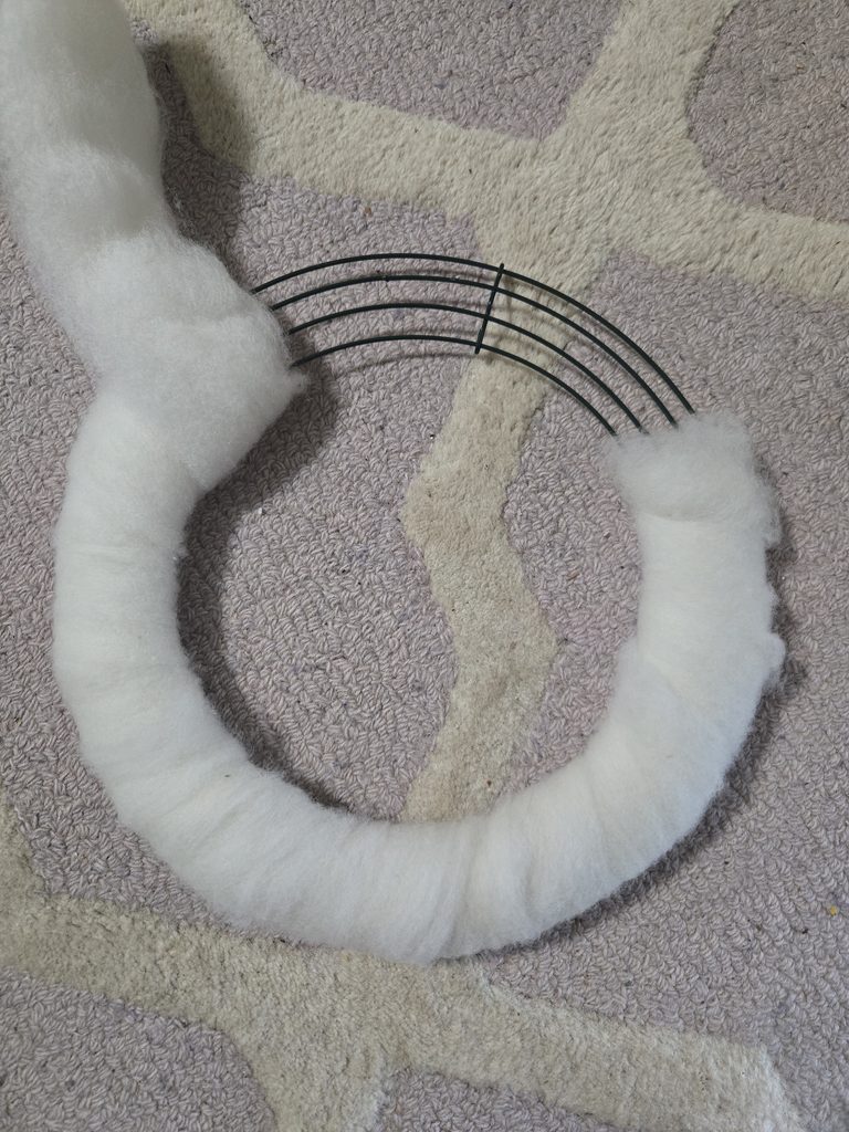 Wrapping a metal wreath frame with wool roving.