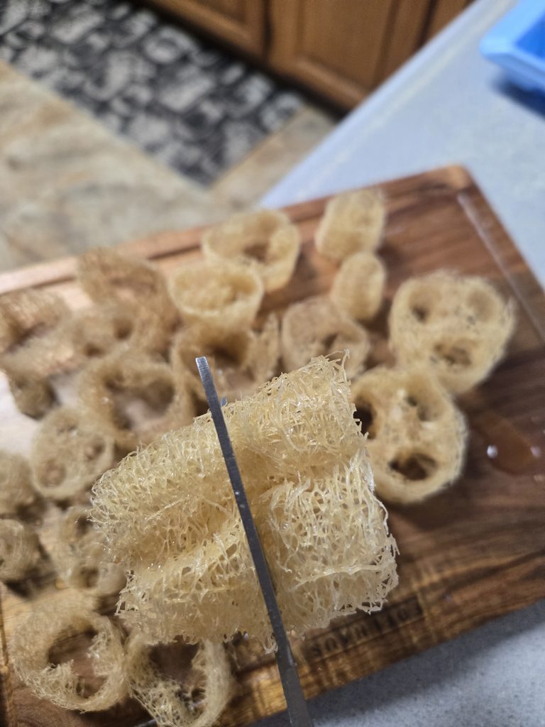 Cutting loofah with scissors.